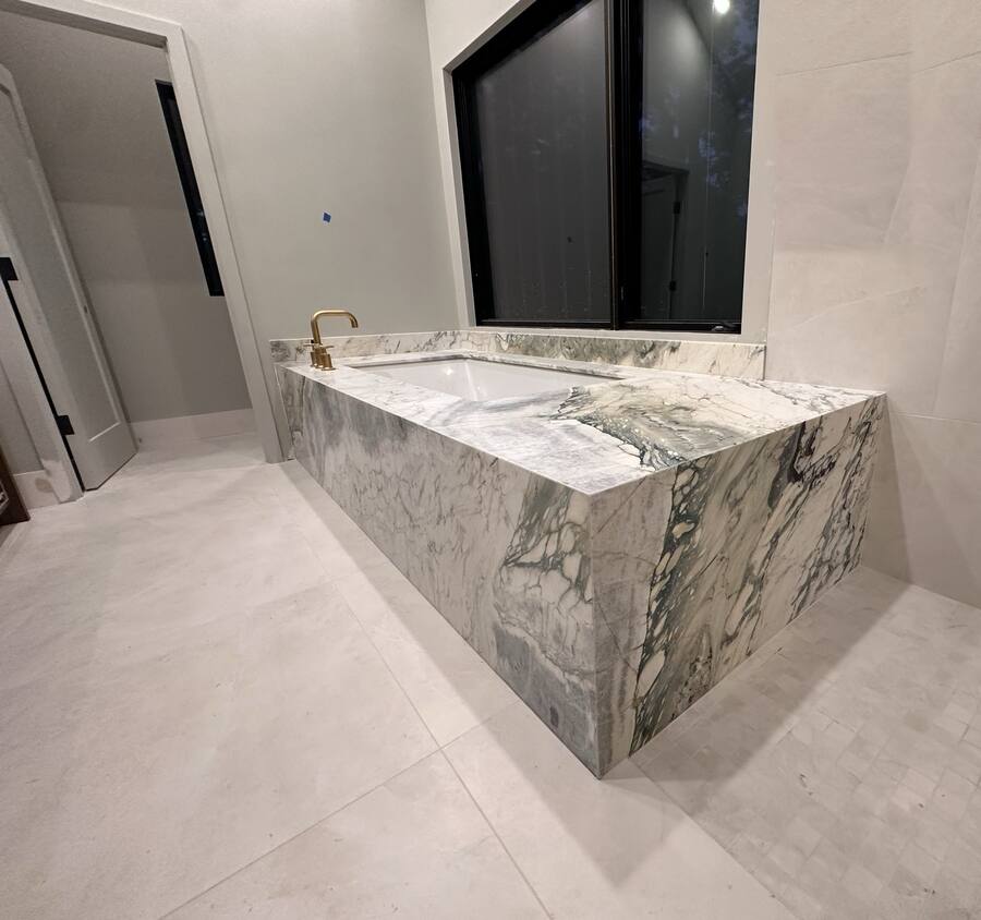 Book-matched marble tub surround with brass filler
