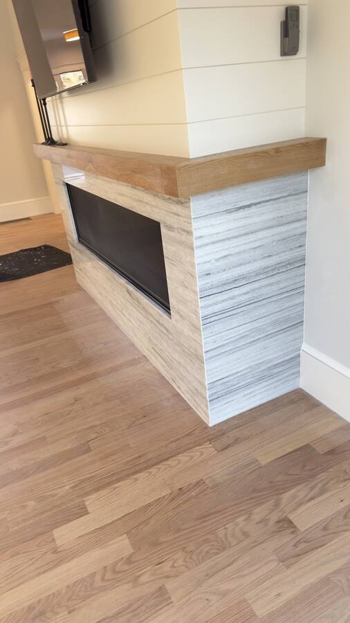 Linear fireplace clad in vein-cut tile