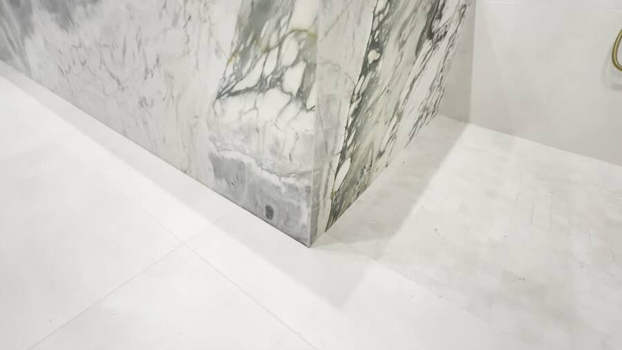 45° mitered stone apron meeting large-format porcelain floor